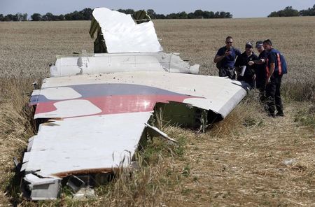 © Reuters. Membros do grupo de especialistas internacionais inspecionam destroços de avião da Malásia que caiu na Ucrânia