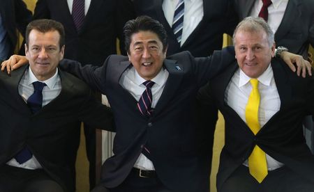 © Reuters. Japan's PM Abe poses for a photo with former Brazilian soccer star Zico and Brazil's new coach Dunga during a meeting with Brazilian soccer players in Brasilia