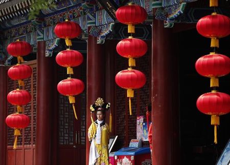 © Reuters. A restaurant promoter wearing a traditional Chinese costume waits for customers, in Beijing