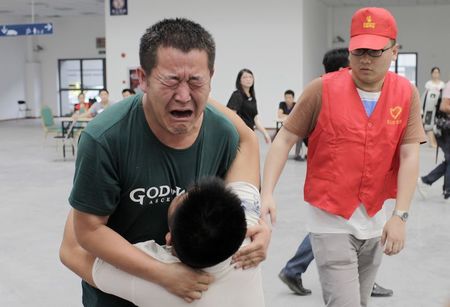 © Reuters. Family members cry at a caring centre for relatives of victims of a factory explosion, in Kunshan