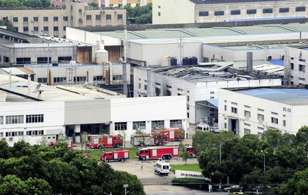 © Reuters. Firefighter trucks are seen next to a damaged building after an explosion at a factory in Zhoushan