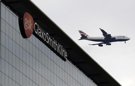 © Reuters. A British Airways airplane flies past a signage for pharmaceutical giant GlaxoSmithKlein in London