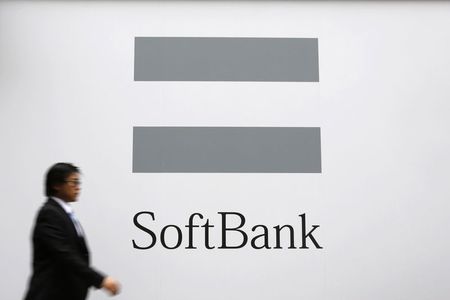 © Reuters. File photo of a man walking past the logo of SoftBank Corp in Tokyo