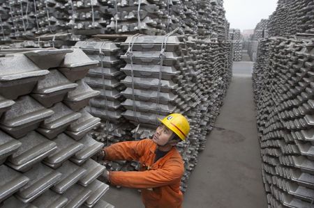 © Reuters. File photo of an employee checking aluminium ingots for export at Qingdao Port