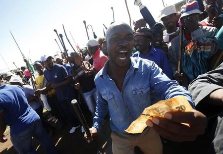 © Reuters. Striking platinum miners sing and dance during a rally near Lonmin's Marikana mine