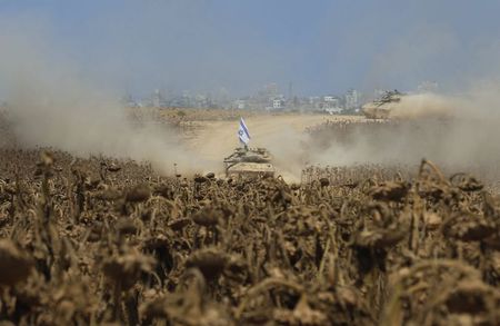 © Reuters. Israeli tanks move near the border as they return to Israel from Gaza