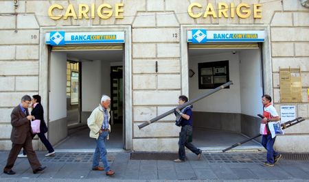 © Reuters. People walk in front of Carige bank in Genoa