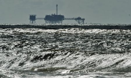 © Reuters. An oil and gas drilling platform stands offshore as waves churned from Tropical Storm Karen come ashore in Dauphin Island, Alabama