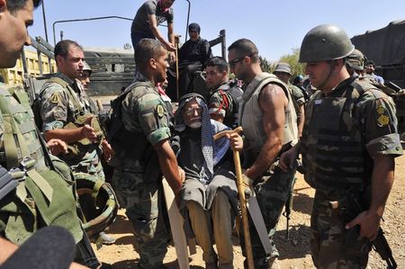 © Reuters. Soldados libaneses ajudam refugiados síria a se retirarem de Arsal, cidade na fronteira com a Síria