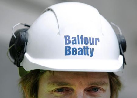 © Reuters. A Balfour Beatty worker walks onto a site in London