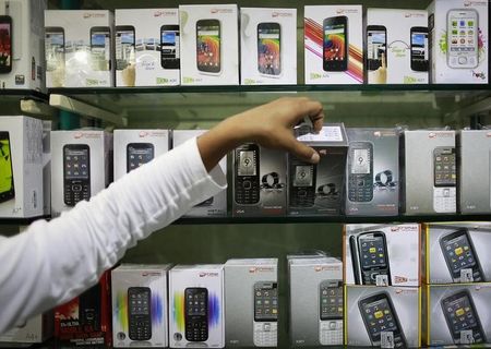 © Reuters. An employee takes out a Micromax mobile phone from the display at a mobile store in Mumbai