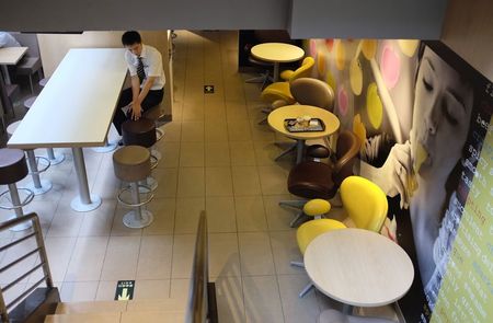 © Reuters. A man sits at a McDonald's store in Beijing