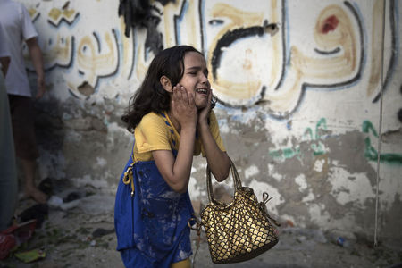 © Reuters. A Palestinian girl reacts at the scene of an explosion that medics said killed eight children and two adults, and wounded 40 others at a public garden in Gaza City