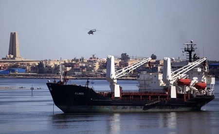 © Reuters. A military helicopter flies above a container ship in the Suez canal near Ismailia port city, northeast of Cairo