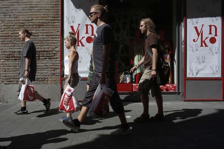 © Reuters. People walk past a shop in Madrid