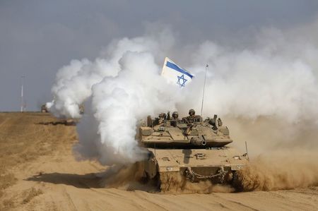 © Reuters. Tanque de guerra israelense cruza a fronteira de volta para  Israel a partir da Faixa de Gaza