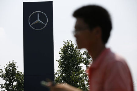 © Reuters. A man walks past a Mercedes-Benz logo outside its Shanghai office