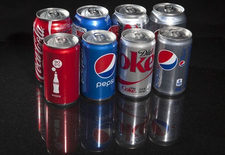 © Reuters. Regular and mini cans of Coke and Pepsi are pictured in this photo illustration in New York