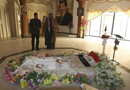© Reuters. Residents pray near the tomb of former Iraqi President Saddam Hussein in Awja near Tikrit