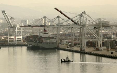 © Reuters. A tug boat passes in front of a freighter at the Port of Oakland in Oakland