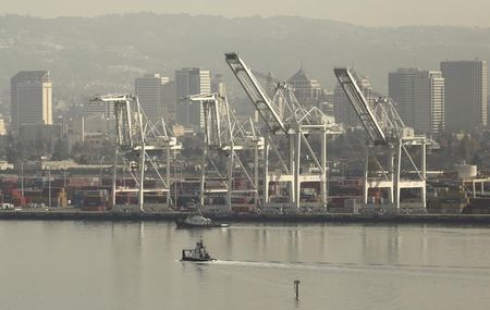 © Reuters. A tug boat passes in front of a freighter at the Port of Oakland in Oakland