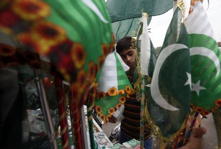 © Reuters. A worker sorts Pakistani flags printed in preparation for the August 14 National Day celebrations, at a printing press in Lahore