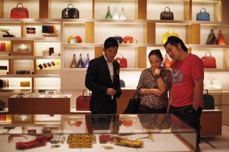 © Reuters. A couple shop at a Louis Vuitton store during Vogue's 4th Fashion's Night Out: Shopping Night with Celebrities in downtown Shanghai