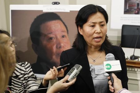 © Reuters. Geng He, the wife of Gao Zhisheng, political prisoner and ChinaÕs leading human rights lawyer speaks in front of her husband's portrait during a news conference on Capitol Hill in Washington