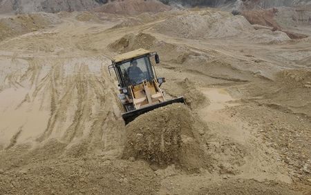 © Reuters. A labourer operates a bulldozer at a site of a rare earth metals mine at Nancheng county, Jiangxi province