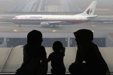 © Reuters. File photo of people looking at a Malaysia Airlines plane at Kuala Lumpur International Airport