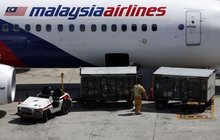 © Reuters. File photo of serviceman loading luggage into Malaysia Airlines plane at Kuala Lumpur International Airport in Sepang