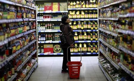 © Reuters. Customer looks at items displayed on shelves at a supermarket in Shenyang
