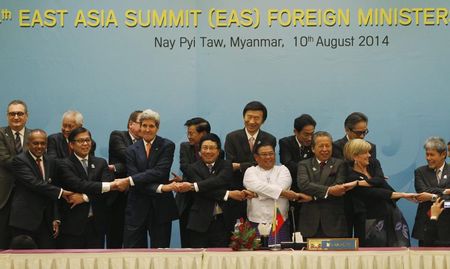 © Reuters. Foreign dignitaries hold hands as they pose for a photo before the 4th East Asia Summit (EAS) Foreign Ministers' meeting in Naypyitaw