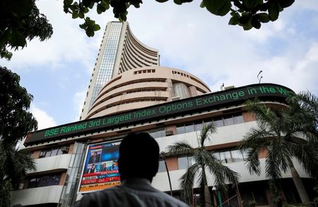 © Reuters. A man looks at a screen across the road displaying the election results on the facade of the BSE building in Mumbai