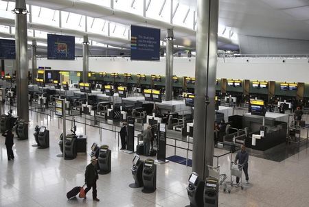 © Reuters. Passengers use the check-in at Terminal 2 at Heathrow Airport