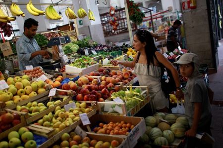 © Reuters. A woman buys fruit in a market in downtown Rome