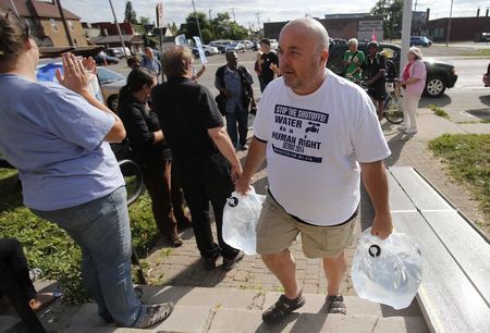 © Reuters. Canadian water activist McGuffin delivers containers of water from Canada to St. Peter's Episcopal church to protest against the increase in water shutoffs for residential customers with unpaid bills in Detroit