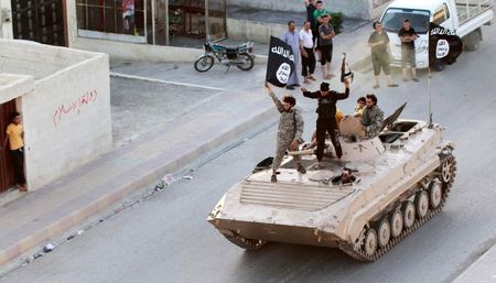 © Reuters. Militant Islamist fighters take part in a military parade along the streets of northern Raqqa province