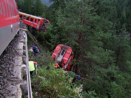 © Reuters. Police and rescue workers help after a passenger train derailed into a ravine near Tiefencastel