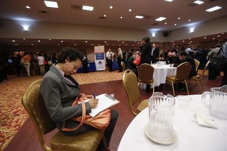 © Reuters. Woman fills out a job application as she attends a job fair in New York