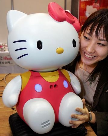 © Reuters. Japonesa ao lado de robô Hello Kitty em feira robótica de Tóquio