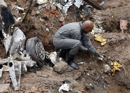 © Reuters. Membro da Força Aérea Brasileira procura destroços de avião que caiu em Santos na quarta-feira, causando a morte do presidenciável Eduardo Campos (PSB) e outras seis pessoas. 