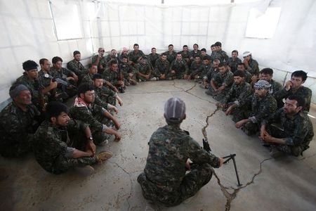 © Reuters. Iraqi volunteers from the Yazidi sect learn how to handle a weapon during a training camp at the Serimli military base, which is controlled by the Kurdish People's Protection Units (YPG), in Qamishli