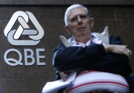 © Reuters. A man waits in front of a QBE Insurance Group headquarters in central Sydney