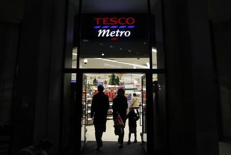 © Reuters. Customers enter and exit a Tesco shop in central London