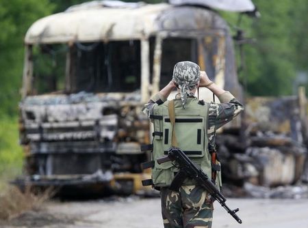 © Reuters. Separatista pró-Rússia perto de caminhão queimado nos arredores de Luhansk