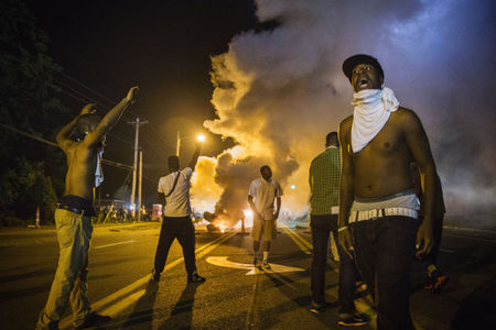 © Reuters. Manifestantes reagem após lançamento de gás lacrimogêneo pela polícia em Ferguson, nos EUA