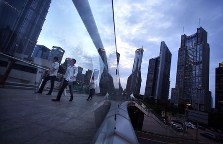 © Reuters. People cross a bridge at Pudong financial district in Shanghai