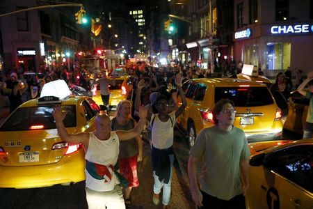 © Reuters. Manifestantes caminham pela ruas de Ferguson contra a morte de um jovem negro desarmado por um policial branco