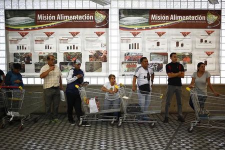 © Reuters. Clientes aguardam em fila de mercado estatal em Caracas